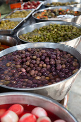Different pickled olives in brine in outdoor market