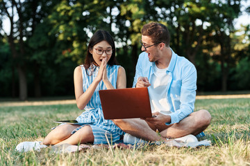 two students with laptop in the park