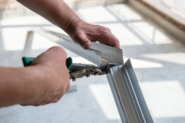 Male worker works with profile for drywall, marker marks for cutting. Construction work, repair....