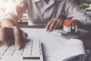 Customers use pens and calculators to calculate home purchase loans according to loan documents...