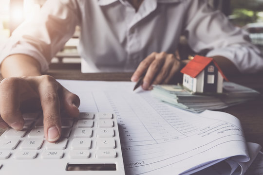 Customers Use Pens And Calculators To Calculate Home Purchase Loans According To Loan Documents Received From The Bank. Real Estate Concept.