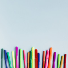 Multicolored markers on blue table