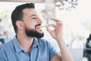 man in restaurant eating chips