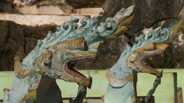Steady, close up of two dragon statues with open mouths.