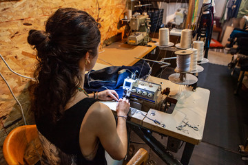 Fashion designer using vintage overlock. An over the shoulder view of a busy dressmaker hard at...