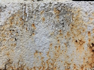 Multicolored background: rusty metal surface with white  paint flaking and cracking texture