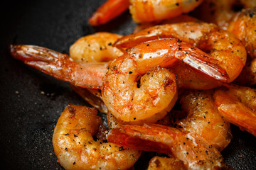 grilled shrimp skewers, lemon, pepper on dark background. barbecue shrimps. shrimp sriracha kebabs