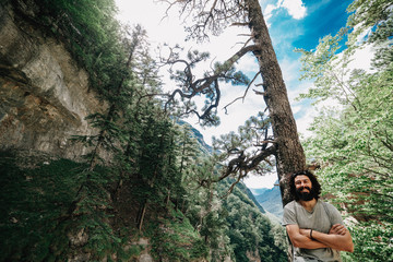 Smiling young man in a forest looking at the camera