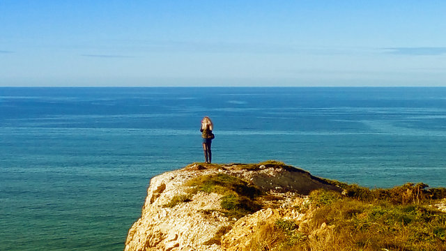 blonde gil standing on the edge clif, seacoast Cantabria sea