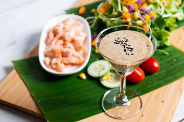 Fresh salad plate with shrimp, salmon, tomato and mixed greens  on wooden background .