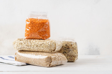 Various cereal grains, groats in transparent plastic bags.