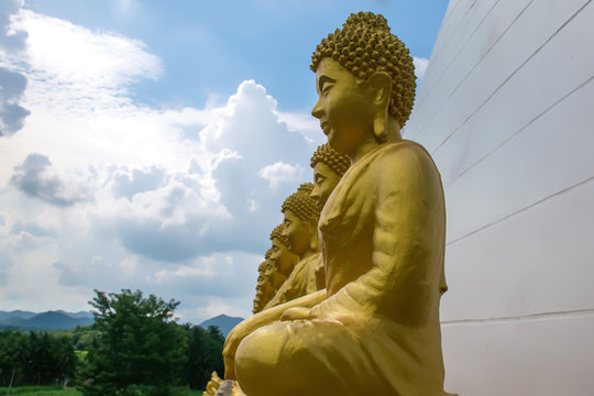 Buddha statue with yellow light.golden Buddha statue with blue sky.