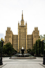 Fototapeta premium Fountain on the background of the historic brick high-rise cloudy summer day Moscow Russia