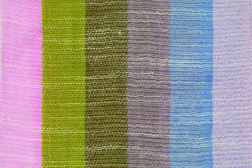 The texture of the light summer striped fabric. The surface of a multi-colored scarf. Close-up.