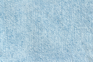 Denim background. Fabric light blue jeans. Close-up.