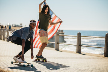 Friends skateboarding on seaside promenade © Jacob Lund