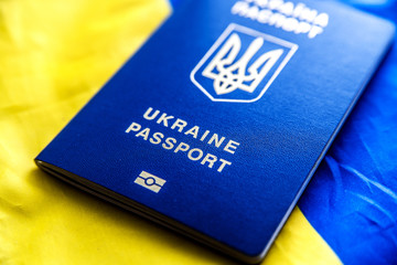 Biometric passport of a citizen of Ukraine against the background of the national blue-yellow flag of Ukraine.