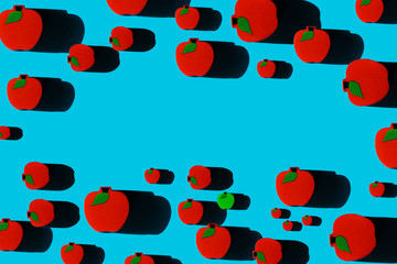 Fototapeta na wymiar Pattern of red and single green toy apples with place for your text. Healthy eating concept. Perfect for the needs of a pediatric doctor etc.
