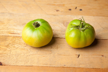 Tomate verde, falta madurar. Tomate arrancado de la mata en estado verde, esperando que madure fuera de la planta.