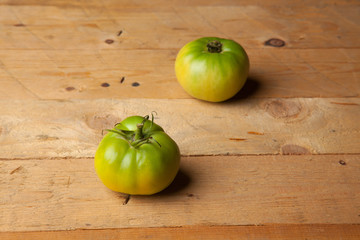 Tomate verde, falta madurar. Tomate arrancado de la mata en estado verde, esperando que madure fuera de la planta.