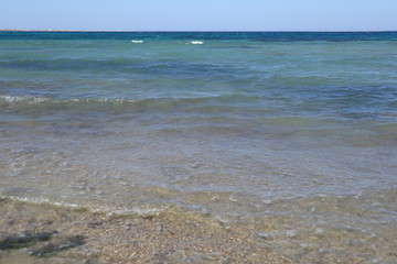 Strand, blaues Wasser und blauer Himmel
