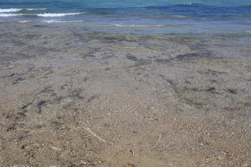 Strand, blaues Wasser und blauer Himmel