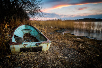 An empty, broken and discarded boat on a shore