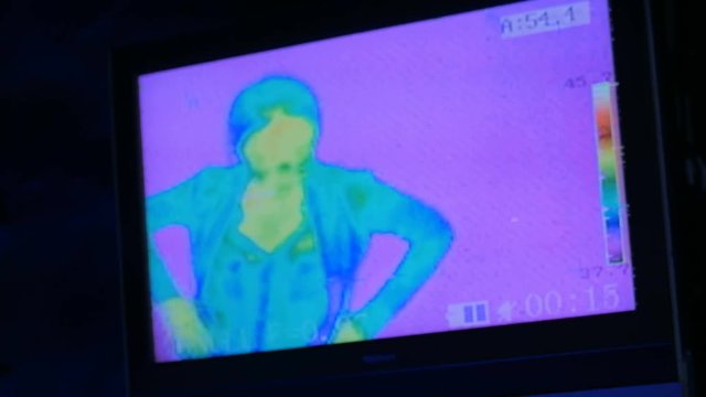 Thermographic camera view of woman. Blue, green, yellow colors show different temperatures
