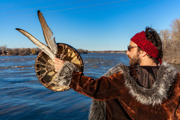 Spiritual man worships natural river. A back view of a healer looking to his side with sacred...