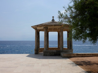 Glorieta de piedra y de construcción clásica con el fondo del mar mediterráneo.