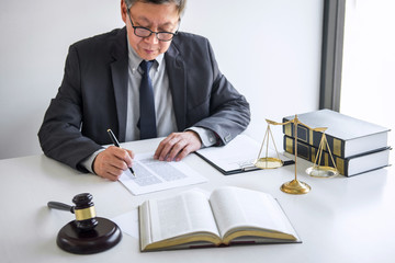 Judge gavel with Justice lawyers, Counselor in suit or lawyer working on a documents in courtroom,...