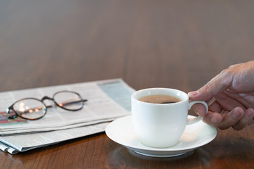 Man hand holding hot coffee cup in the morning