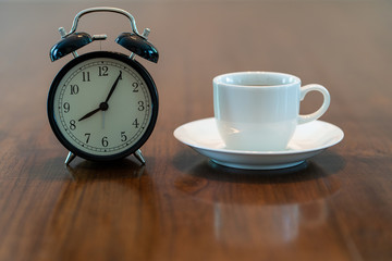 Fototapeta na wymiar Hot coffee cup and vintage clock time at 8 o'clock in the morning