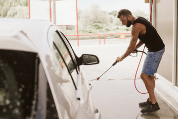 Car washing. Cleaning car using high pressure water.