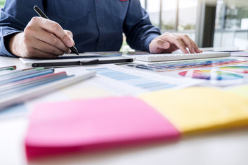 Male creative graphic designer working on color selection and color swatches, drawing on graphics...