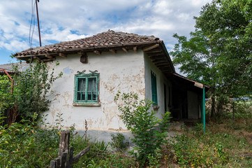 Old traditional house in a village in south-east Romania with a banner that reads 