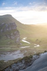 river in the mountains with rocks at sunset