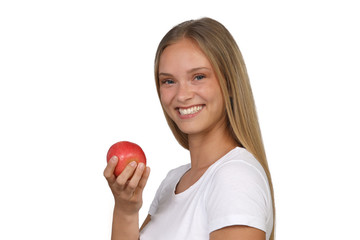 Junge blonde Frau hält einen Apfel in der Hand und lacht