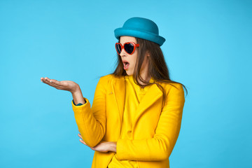 woman in a hat with glasses surprised on a blue background