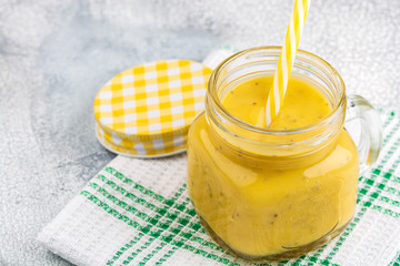 Smoothie with tropical fruits: mango, banana, avocado, chia seeds in a glass jar