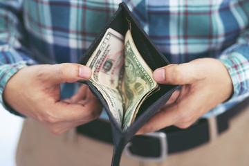 close up business man standing  hand hold Count the money spread of cash wallet. concept finance Saving money.