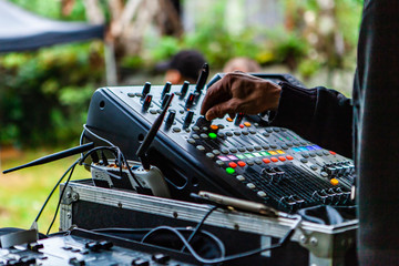 Fusion of cultural & modern music event. A close up view on the hand of a disc jockey as he...