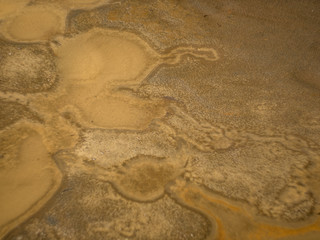 streaks of sand at the bottom of the puddle