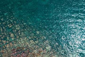 Aerial view of rocky seaside. Rocky stones in the ocean. Aerial photography of beautiful rocky seashore.