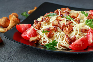 chanterelle pasta with mushrooms and tomatoes on a dark background