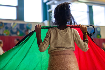 Kindergarten children educational game. A closeup and rear view of a young black girl holding a...