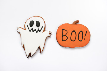 The hand-made eatable gingerbread Halloween ghost and pumpkin with boo inscription on white...