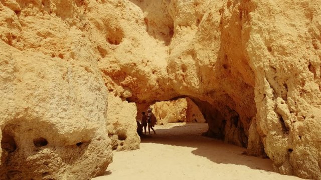 Walking through the stunning caves and rock formations of the Tres Irmaos beach in Alvor, The Algarve, Portugal