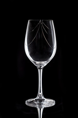 Cracked glass wine glass over black background
