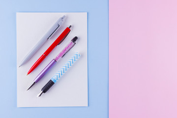 Back to school pop art concept. School stationery on pink blue background. Multicolored pens on pastel background. Flat lay. Copy space
